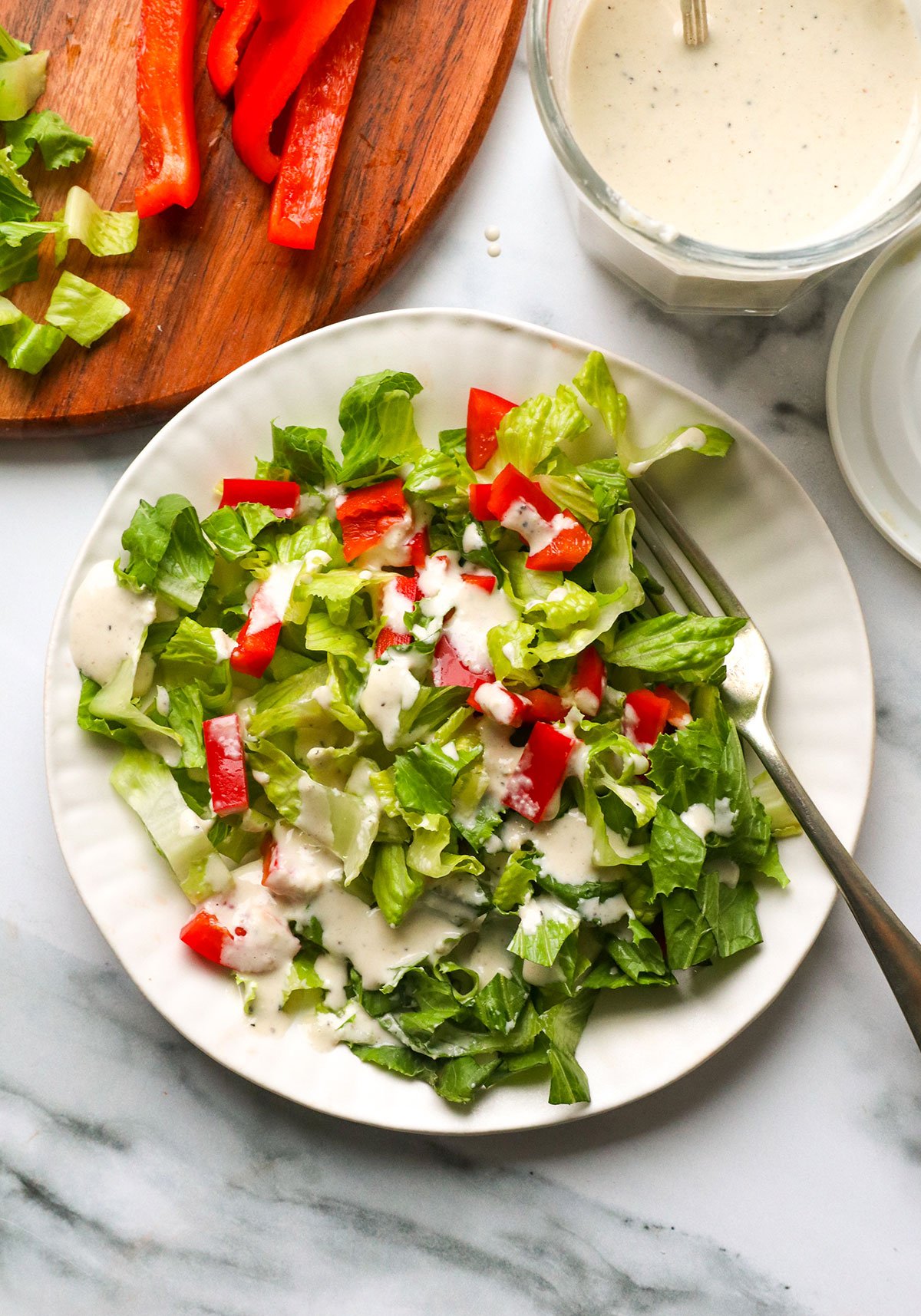 tahini dressing served over a green salad with red peppers. 