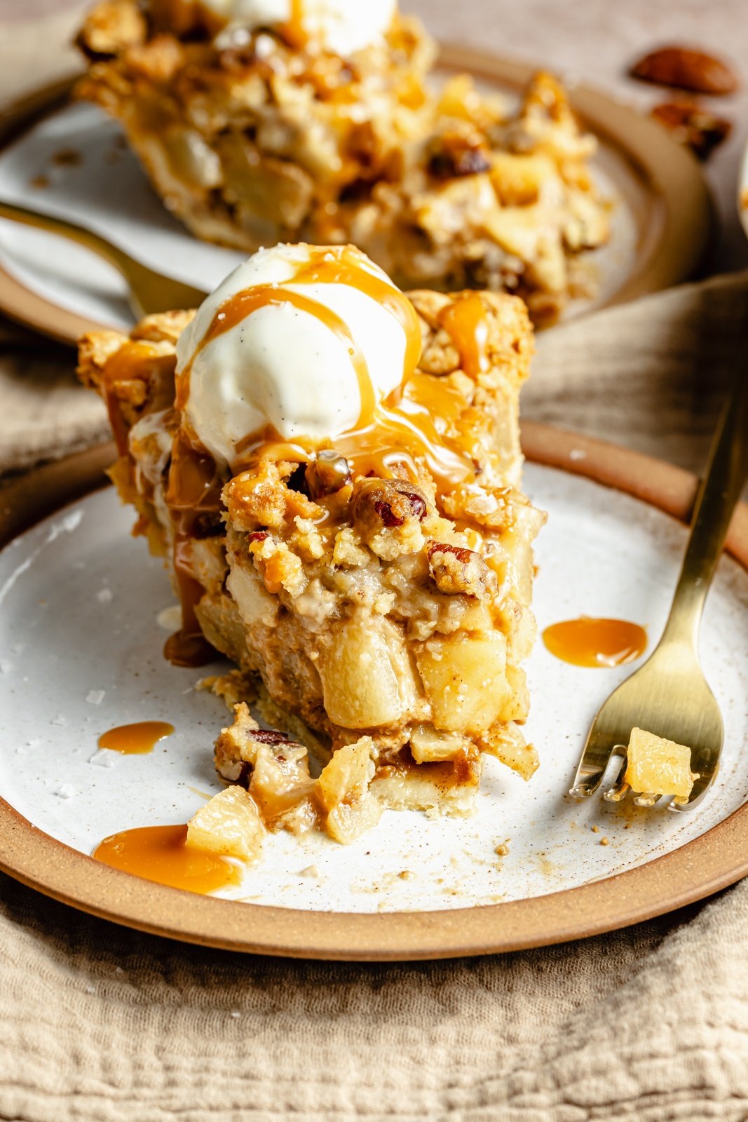 slice of salted caramel pear pie on a plate with ice cream