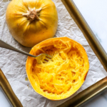 spaghetti squash prepared on a baking sheet and fluffed with a fork.