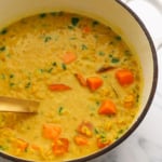 sweet potato lentil curry in a big pot with a ladle.