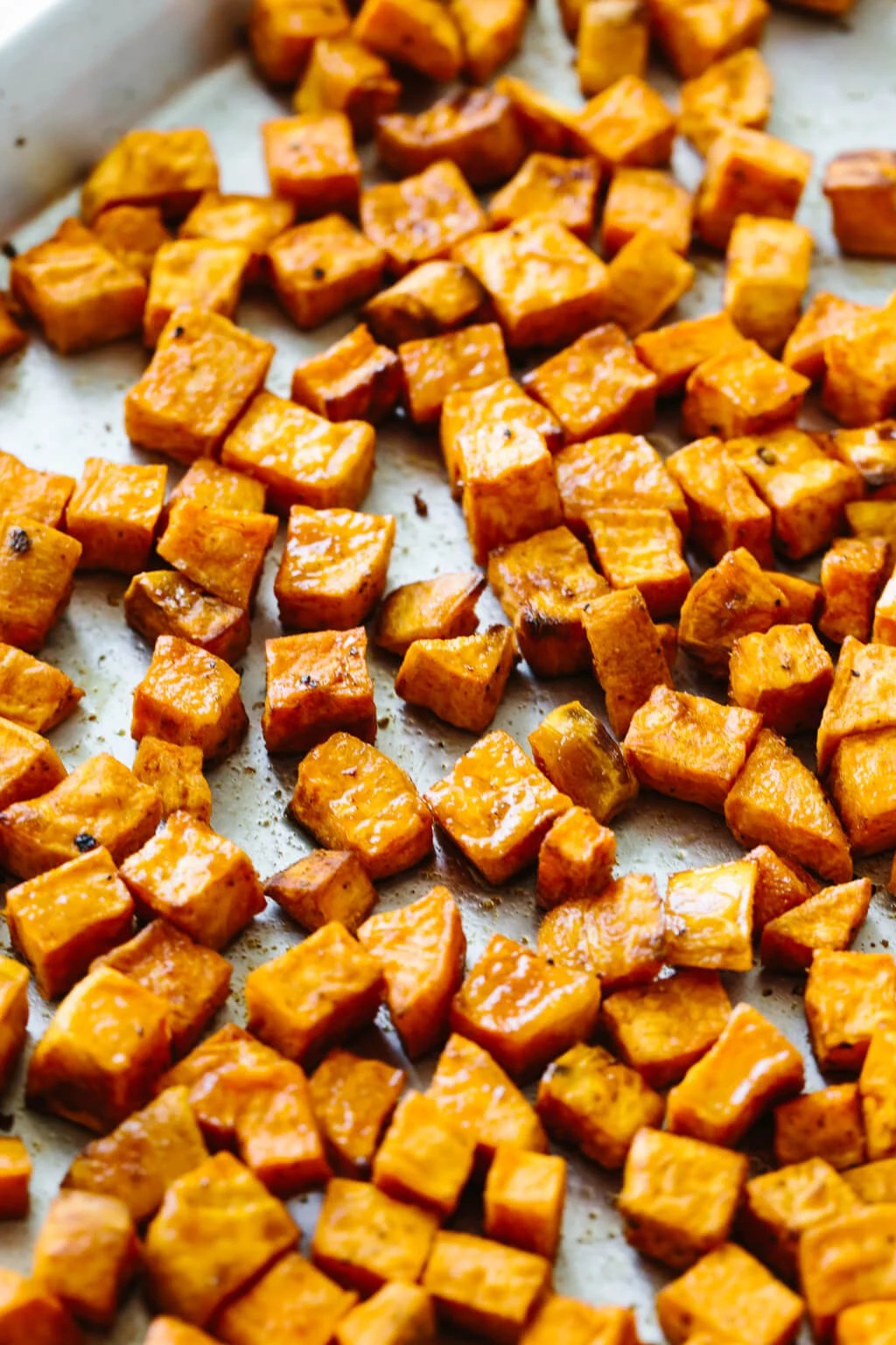 Roasted sweet potatoes on a sheet pan.