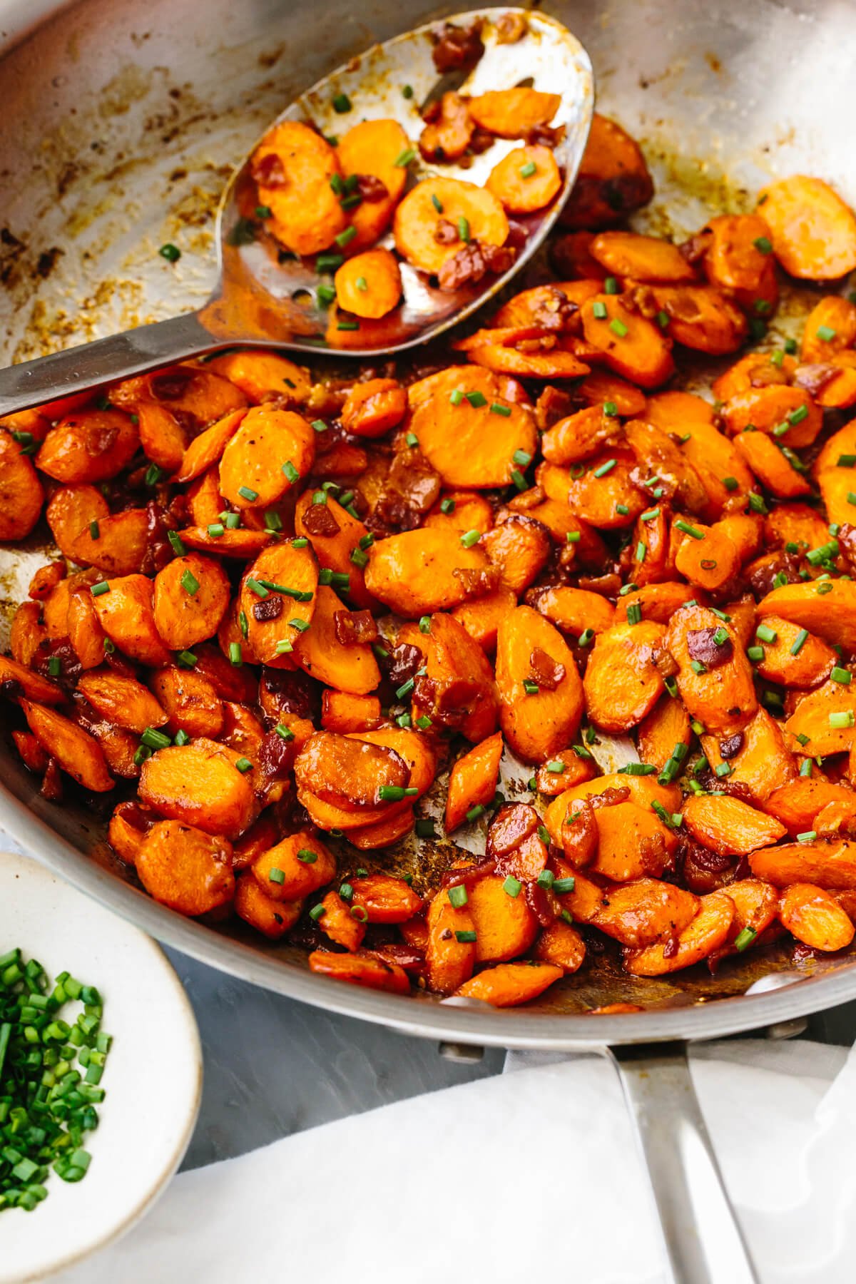 Sauteed carrots with bacon Dijon dressing in a pan