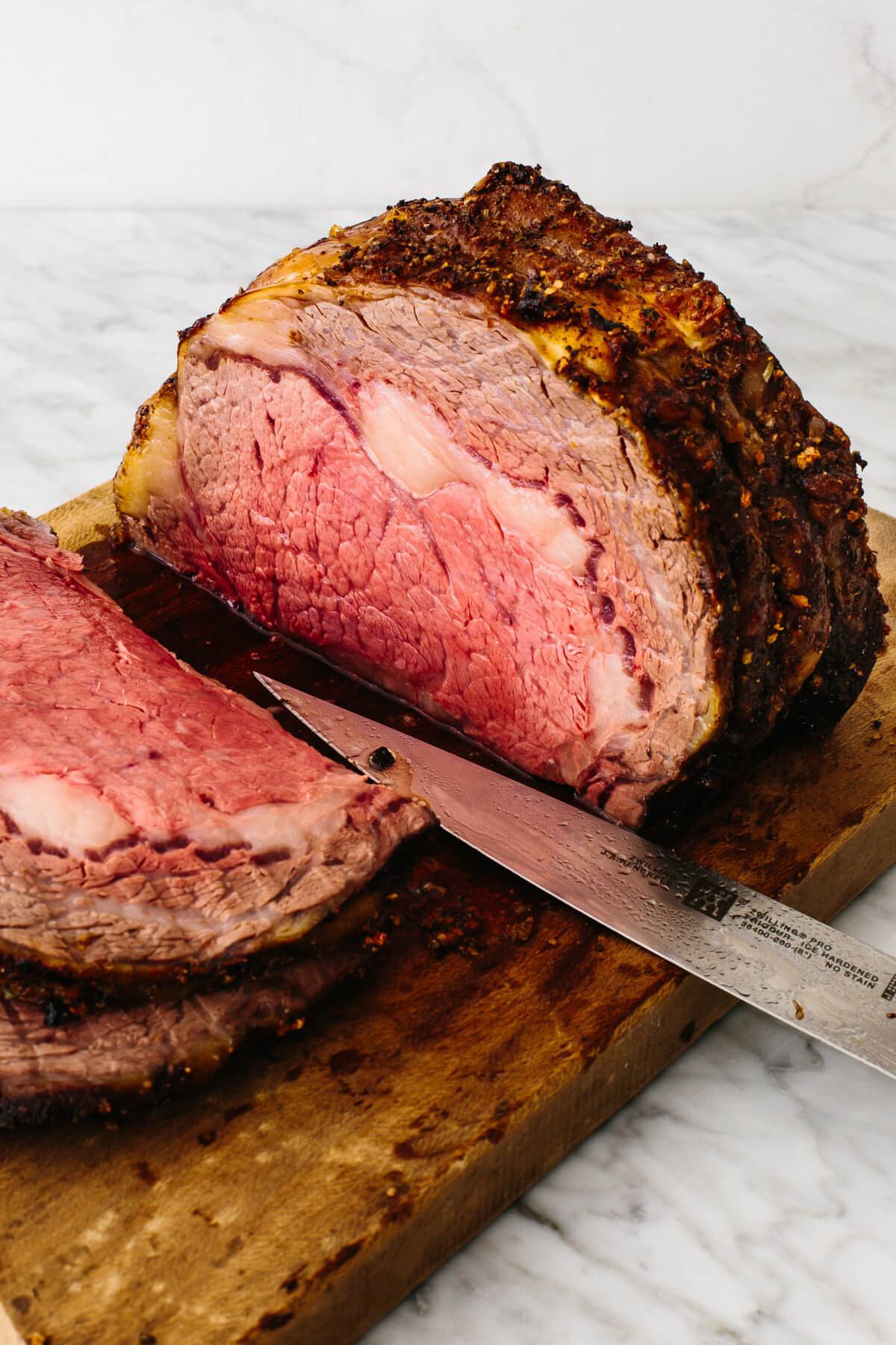 Prime rib sliced on a cutting board.