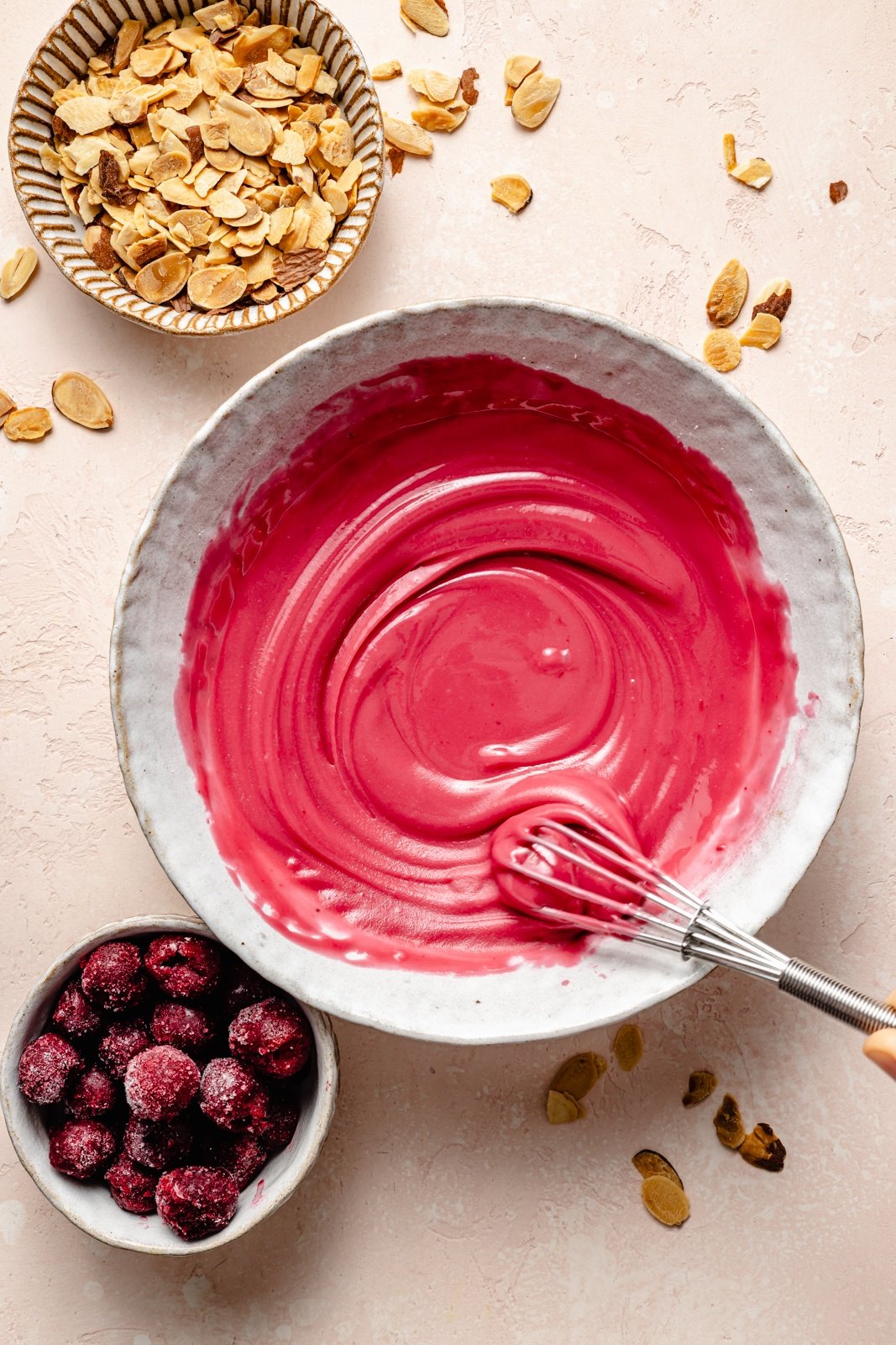 mixing cherry icing for cherry almond oatmeal cookies in a bowl