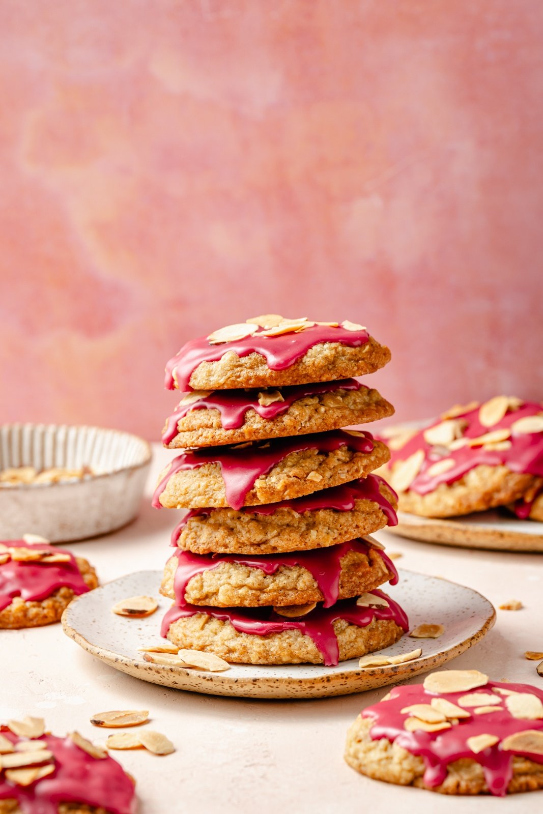 almond oatmeal cookies with cherry icing in a stack on a plate