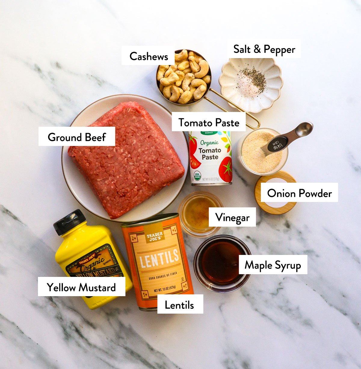 ground beef, lentils, cashews, tomato paste, and mustard labeled on a white surface. 
