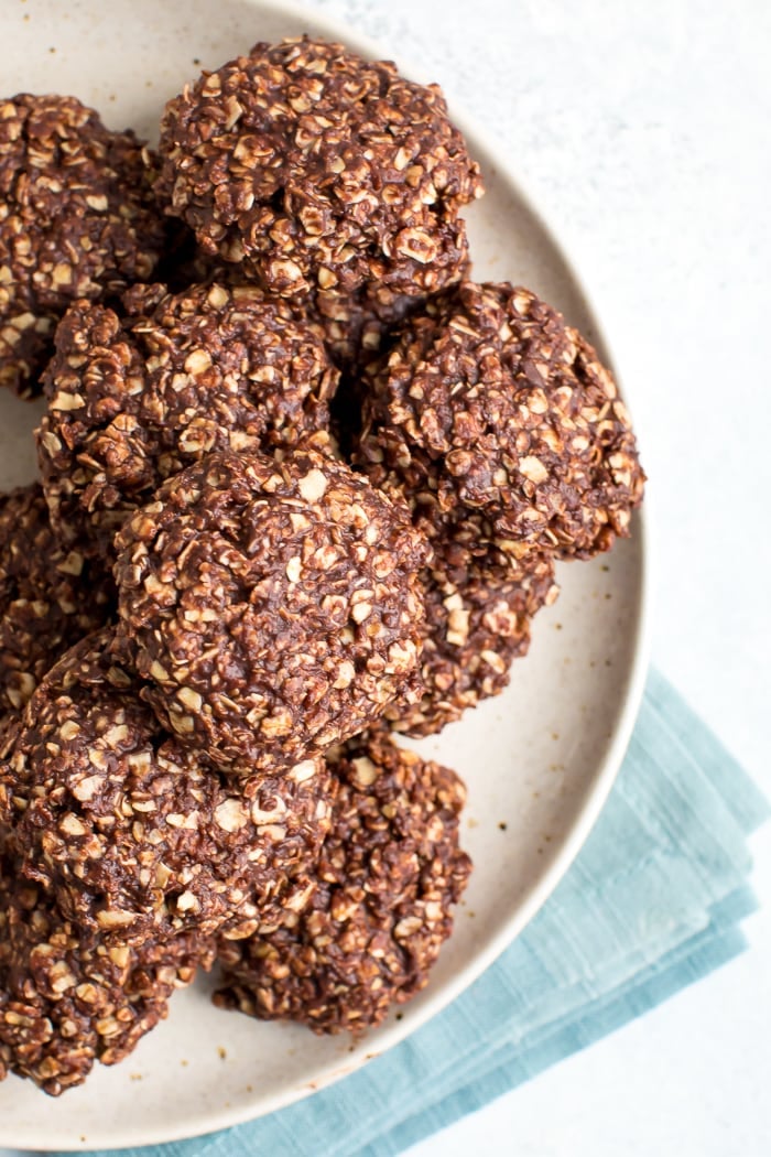 Plate full of peanut butter chocolate healthy no bake cookies with a folded blue napkin below the plate.