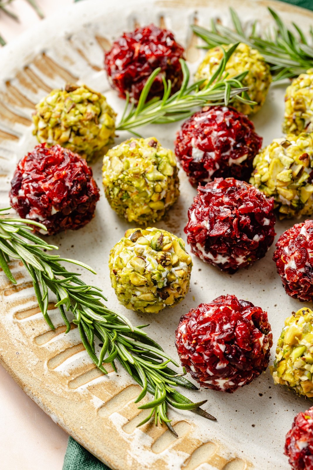 easy cheese truffles rolled in pistachios and dried cranberries on a platter