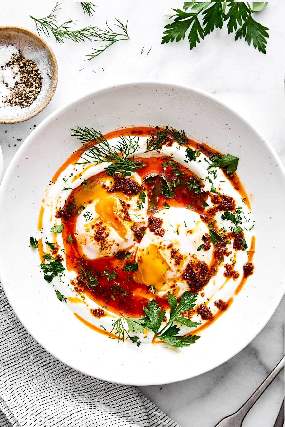 A plate of Turkish eggs with herbs.