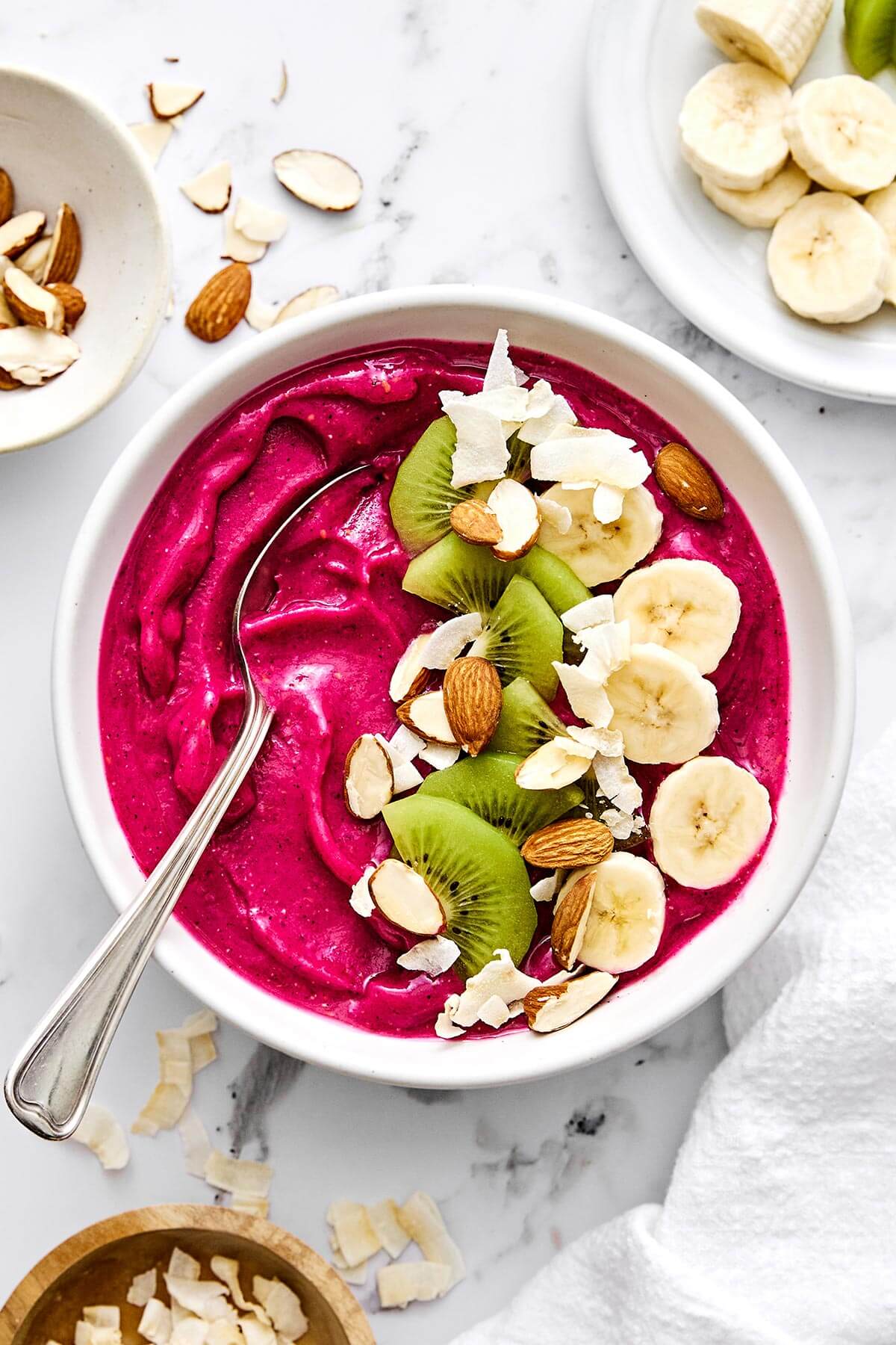 Pitaya smoothie bowl with fruits on top.