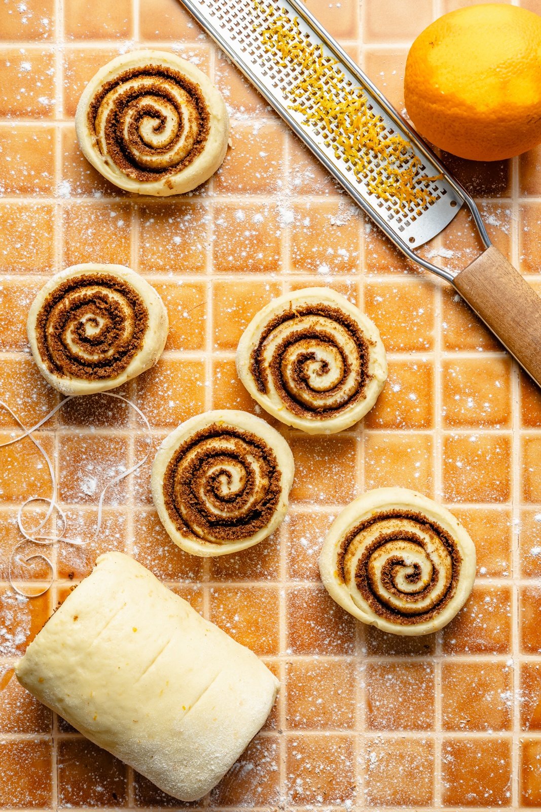 orange cinnamon roll dough sliced into rolls