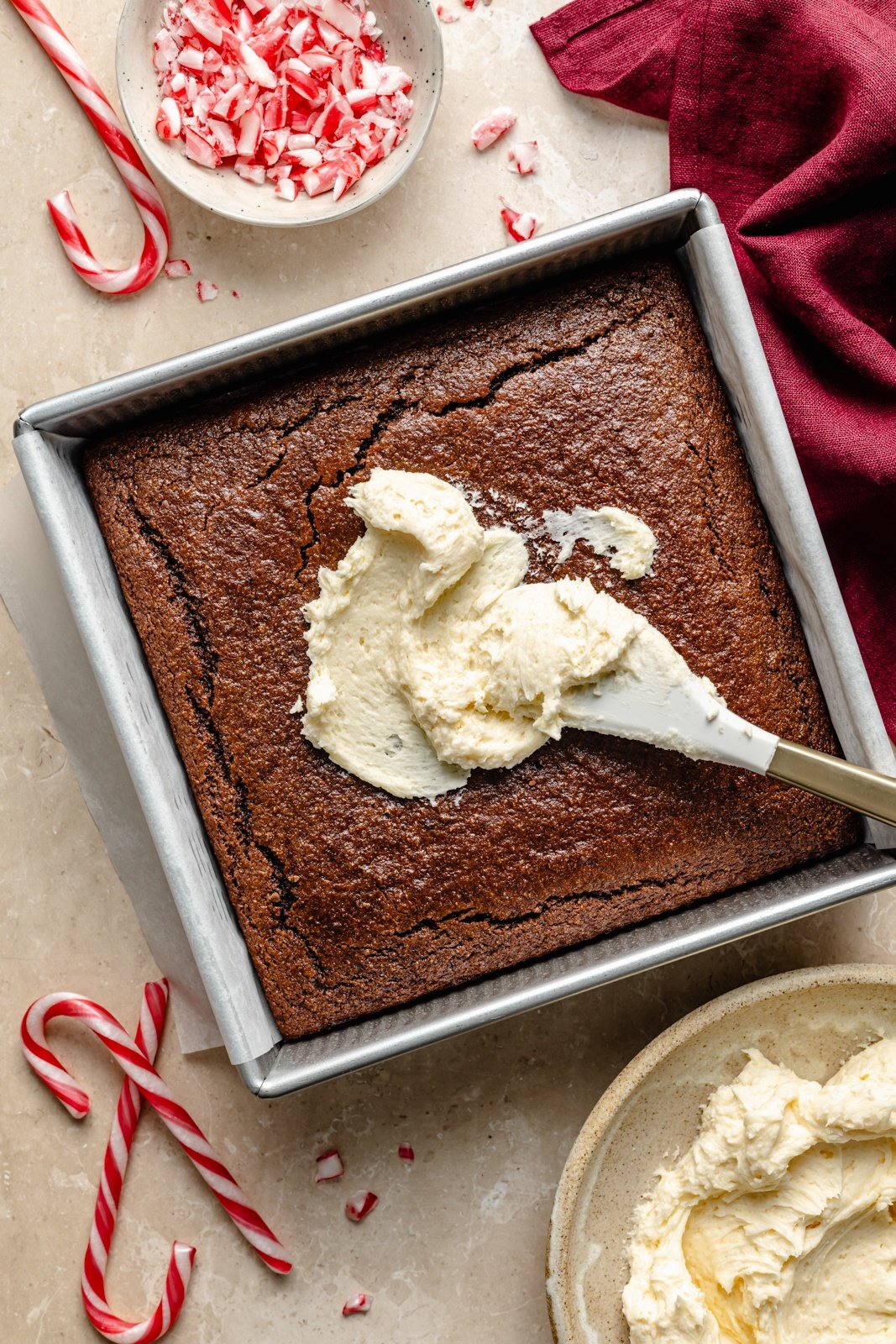 adding frosting to chocolate peppermint cake