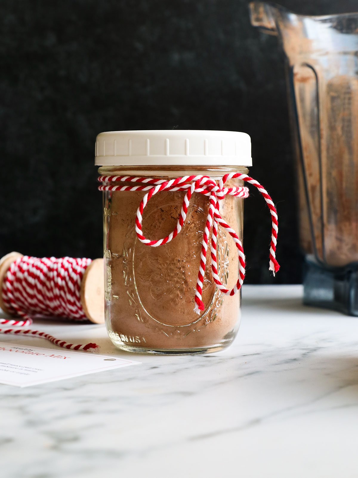hot chocolate mix jar tied with ribbon for a gift. 