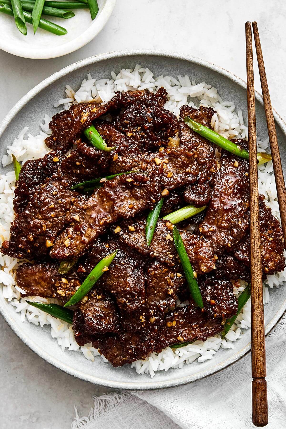 Mongolian beef on rice on a plate.