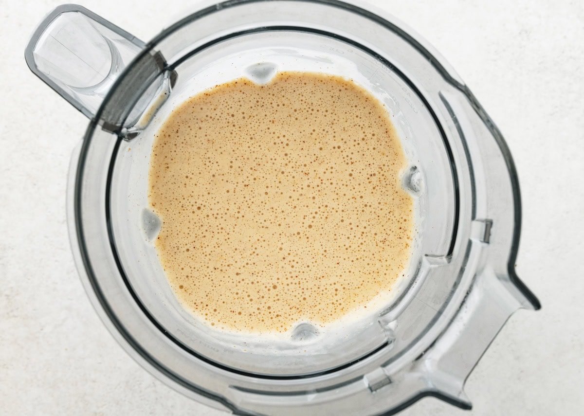 Blended salted caramel protein shake inside a blender jar showing a smooth, creamy texture.