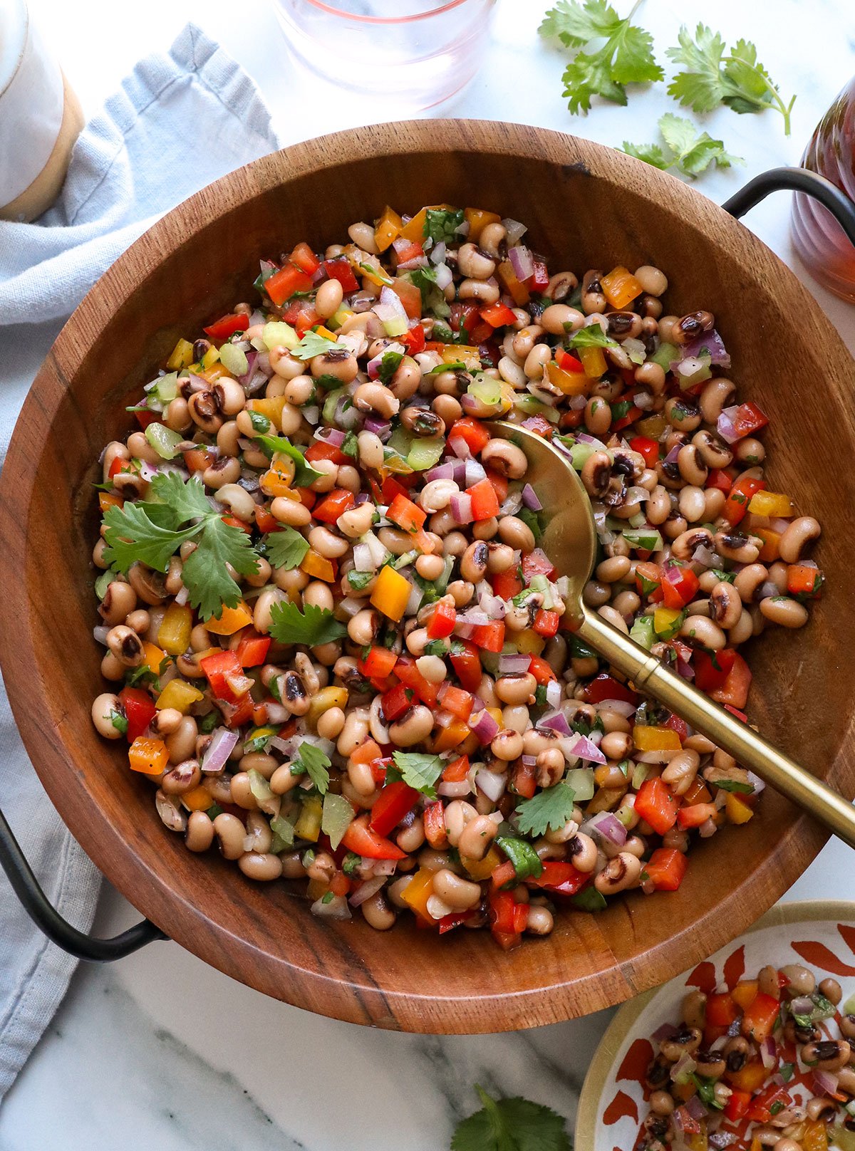black eyed pea salad served in a wooden salad bowl with a spoon.