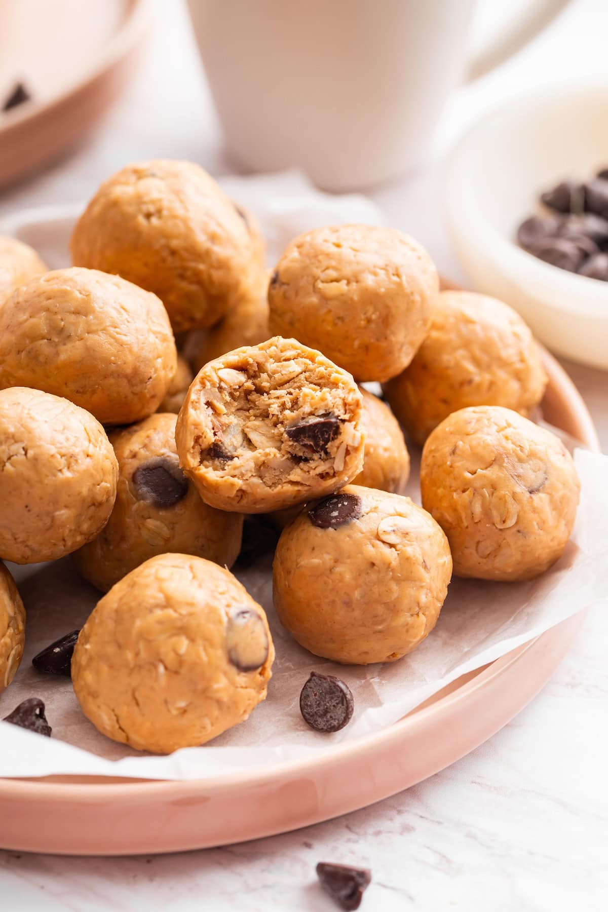 Stack of peanut butter protein balls with one cut open to show the soft center.