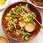 wooden bowl filled with ground beef, lettuce, and special sauce.