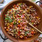 black eyed pea salad served in a wooden salad bowl with a spoon.