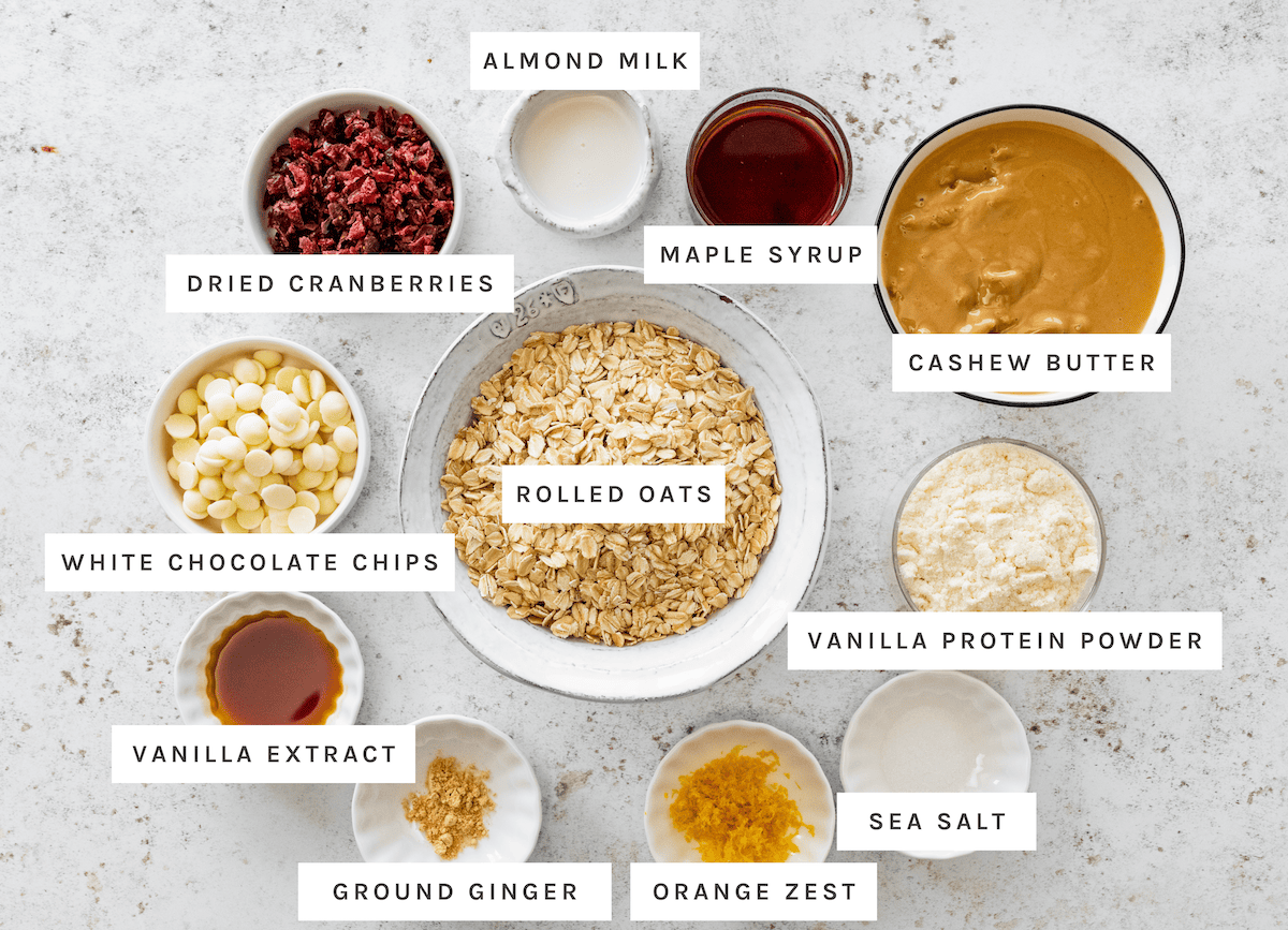 Almond milk, maple syrup, cashew butter, vanilla protein powder, sea salt, orange zest, ground ginger, vanilla extract, white chocolate chips, dried cranberries, rolled oats