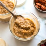 pumpkin chia pudding lifted on a spoon from a jar.