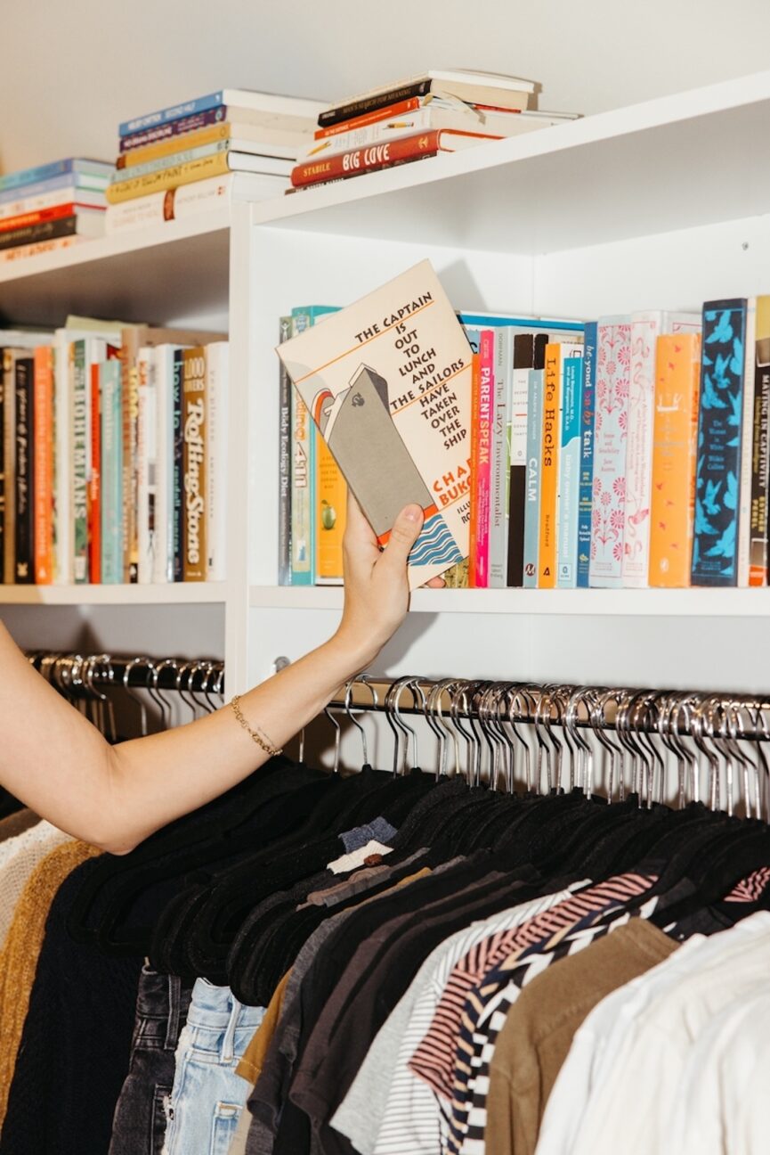 Woman pulling book from shelf.