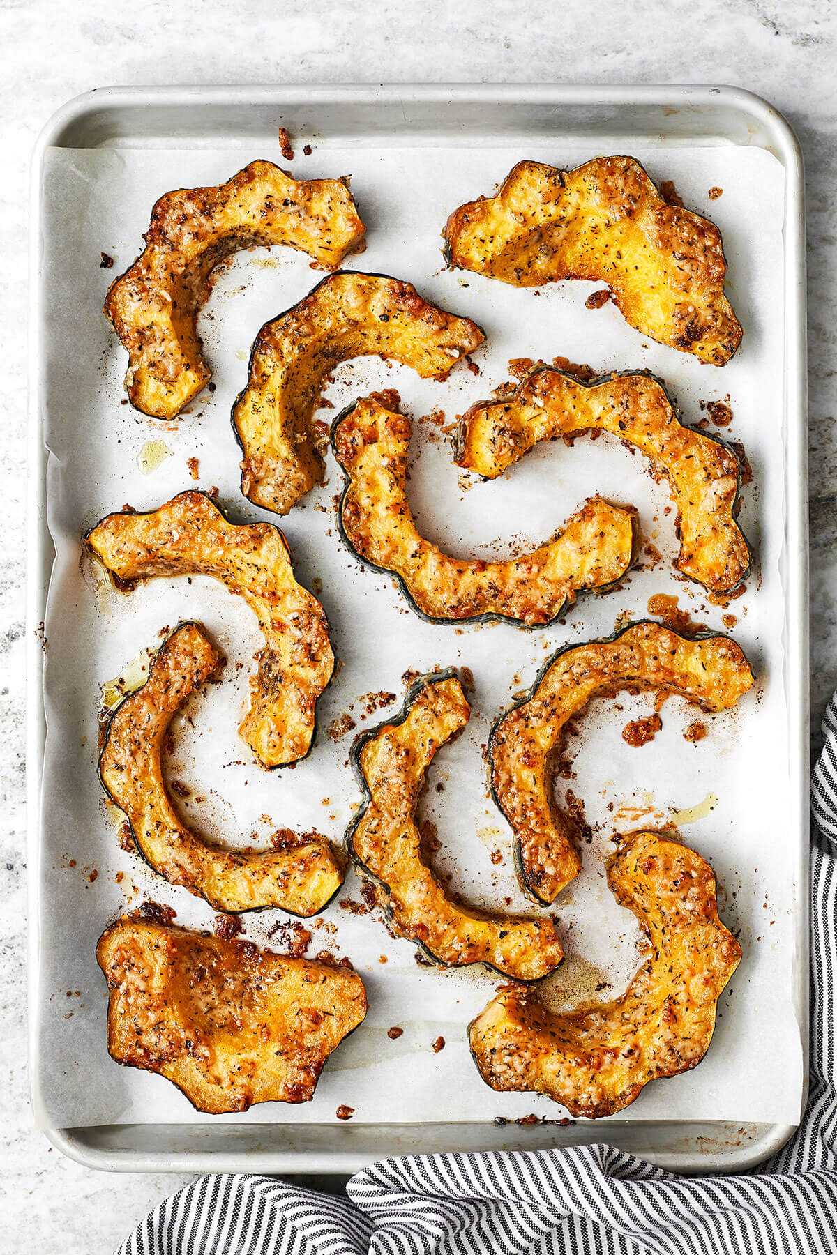 A baking sheet filled with parmesan herb roasted acorn squash