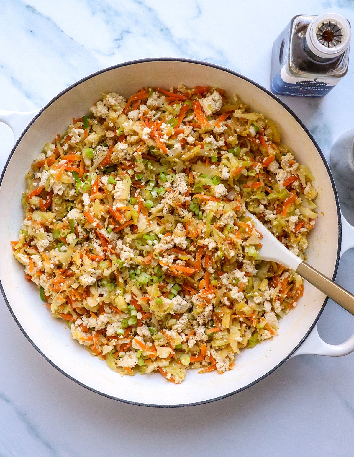 egg roll in a bowl with tofu in a large white skillet. 