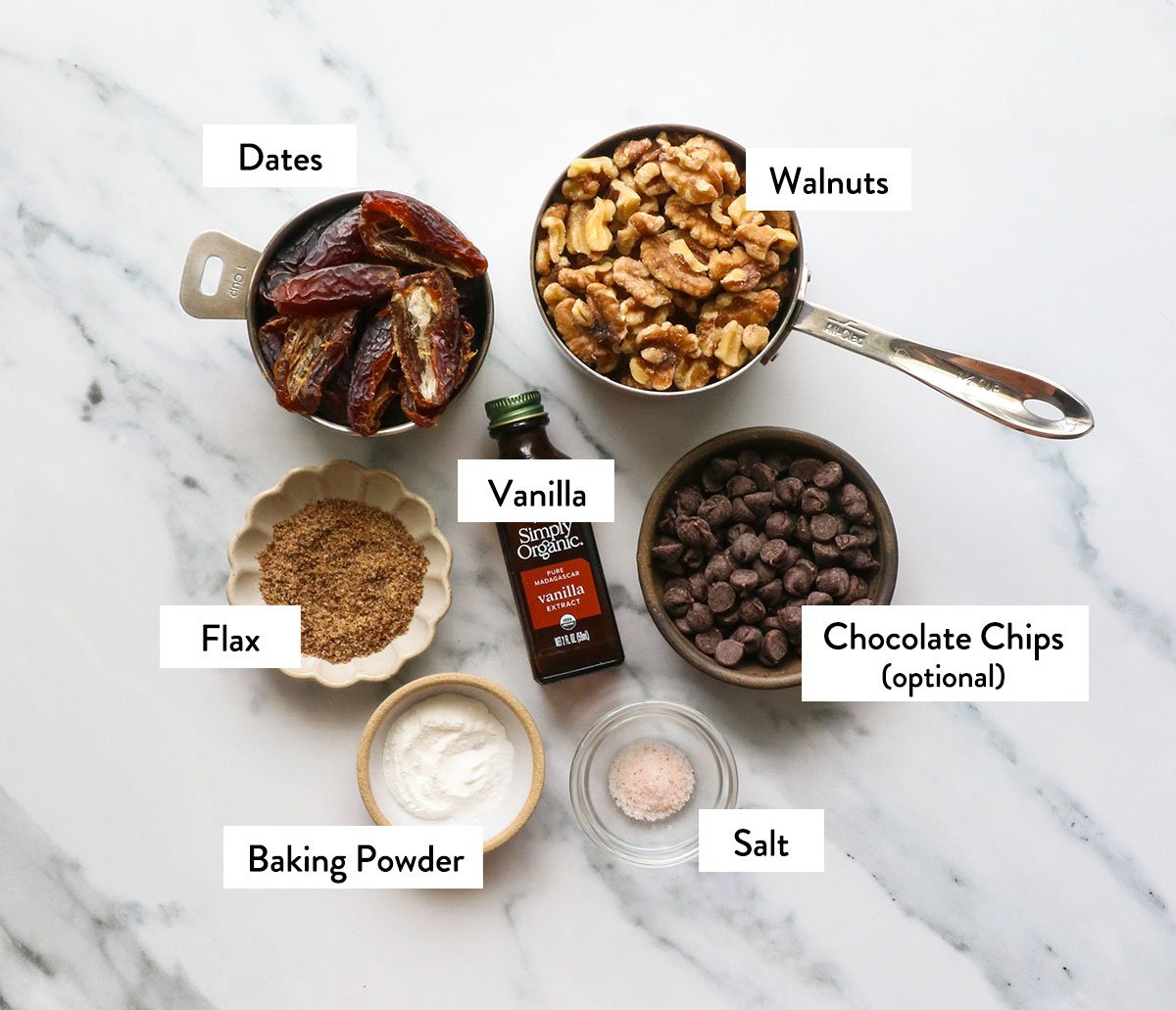 walnuts, dates, vanilla, baking powder, and flax seeds labeled on a white surface.