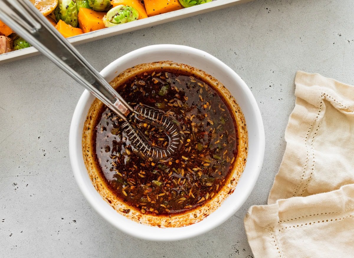 Marinade mixed together in a small white bowl for the chicken and veggies.