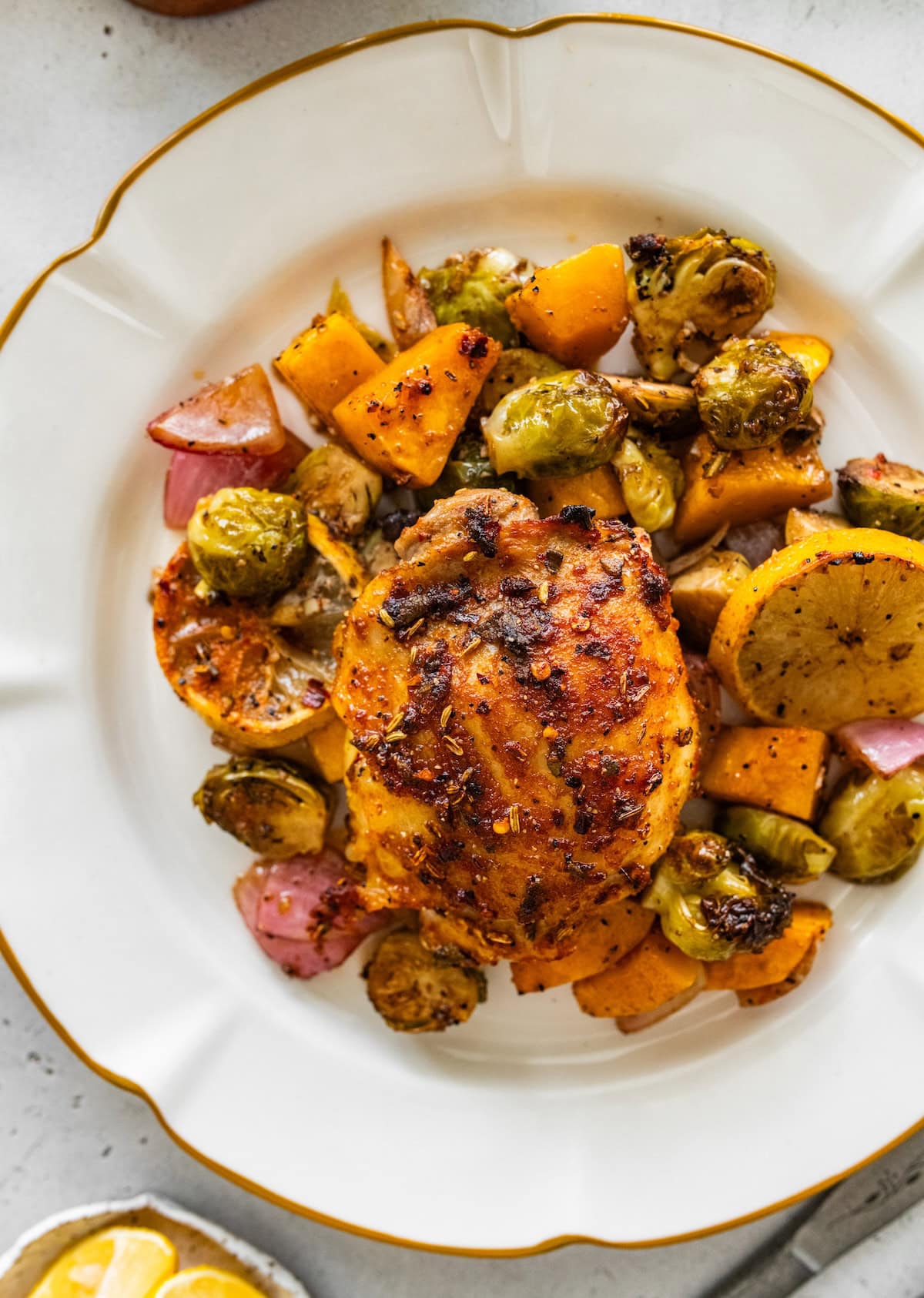 Plated sheet pan chicken and veggies with roasted Brussels sprouts and butternut squash.