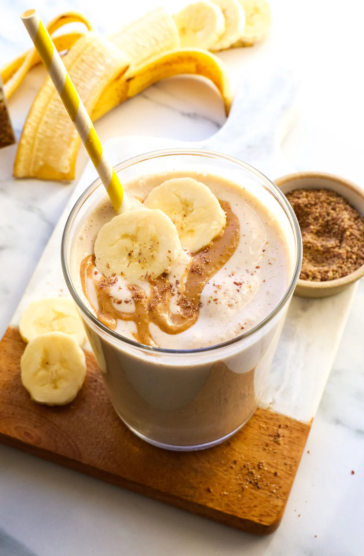 smoothie in a glass topped with peanut butter and banana slices. 