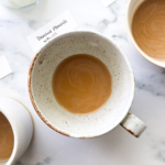 coffee with dairy free creamer inside a white mug.