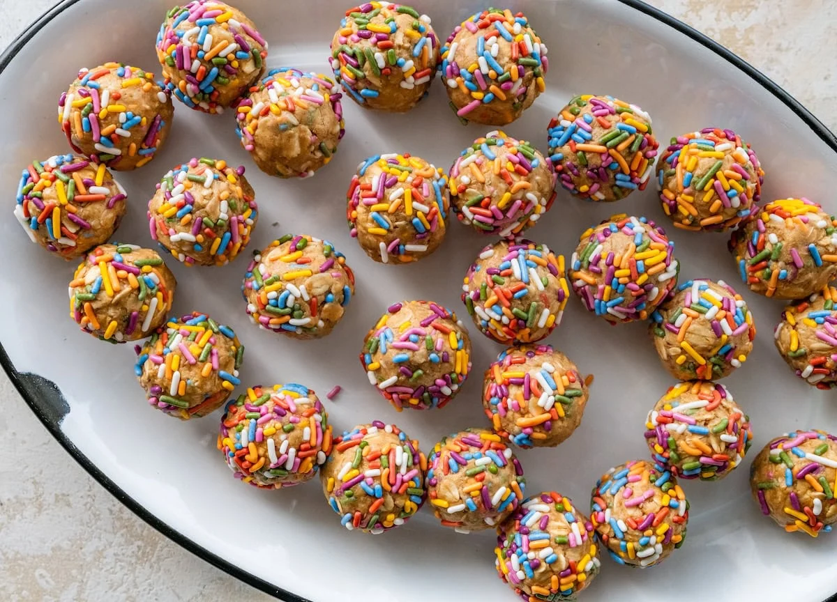 A large dish full of birthday cake protein balls with colorful sprinkles.