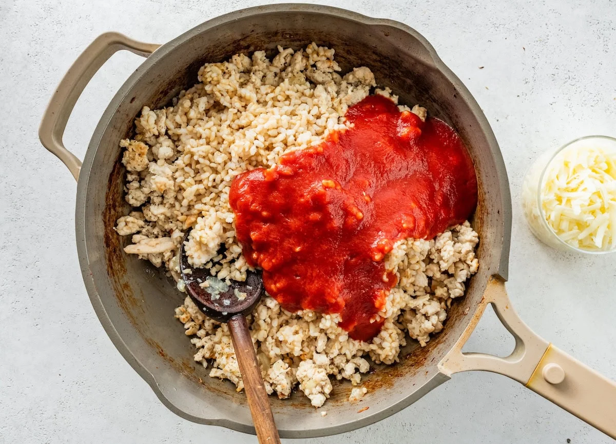 A pan with cooked ground turkey and tomato sauce.
