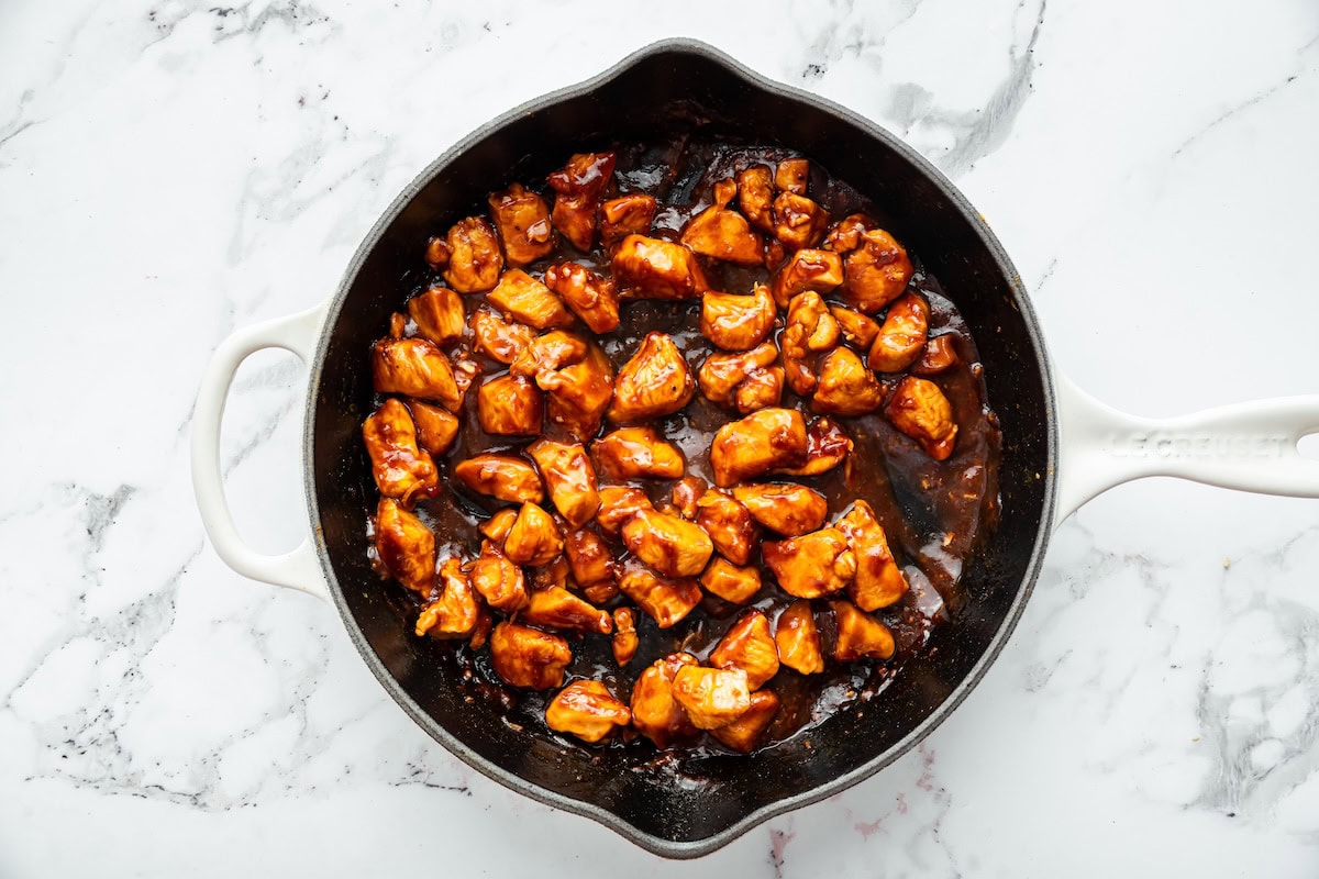 Diced chicken cooking in a skillet, starting to brown for an easy homemade glazed chicken.